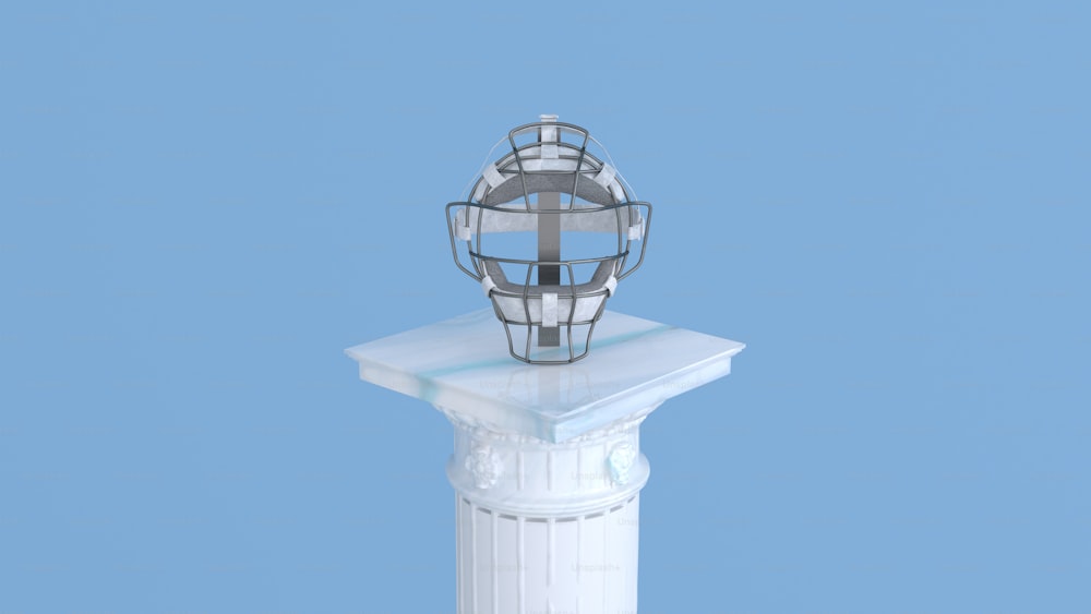 a metal object sitting on top of a white pillar