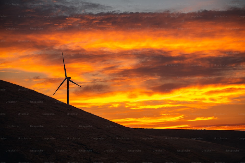 Una turbina eólica sentada en la cima de una colina