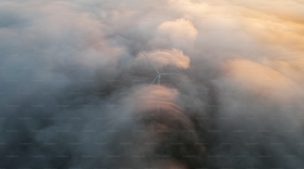 Una vista aérea de una turbina eólica rodeada de nubes