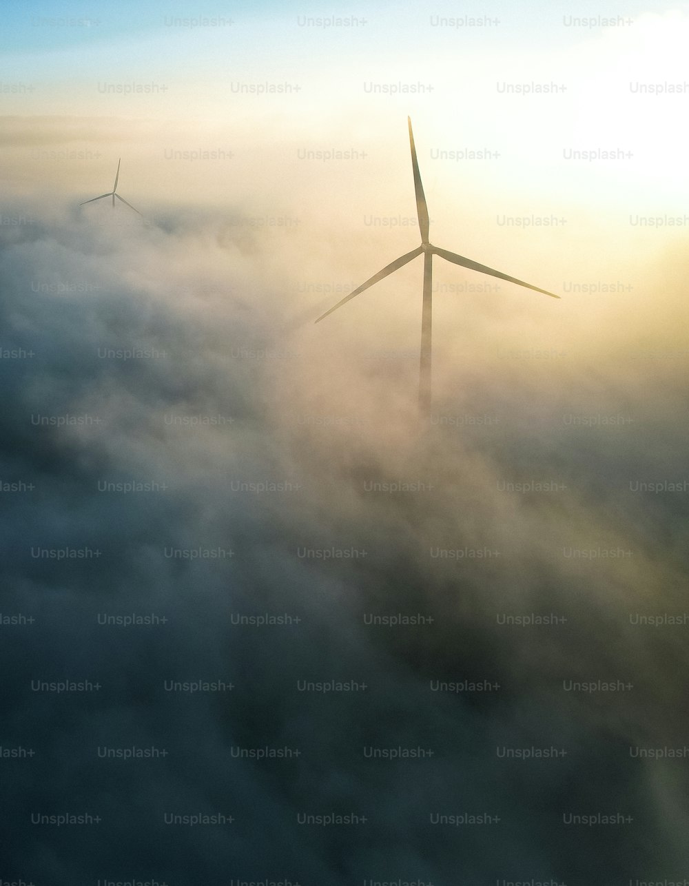 a wind turbine in the middle of a foggy sky