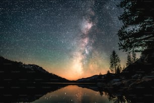 the night sky is reflected in a lake