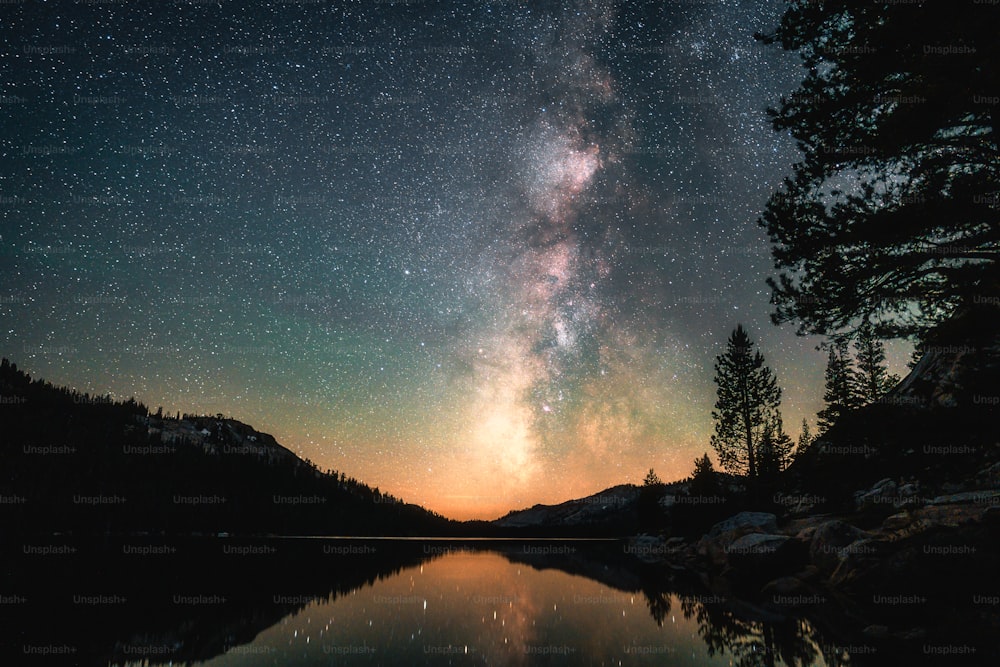 the night sky is reflected in a lake