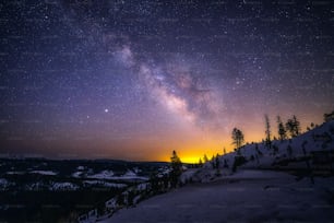 a view of the night sky over a snowy mountain