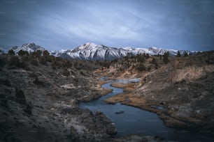 a river running through a valley surrounded by mountains