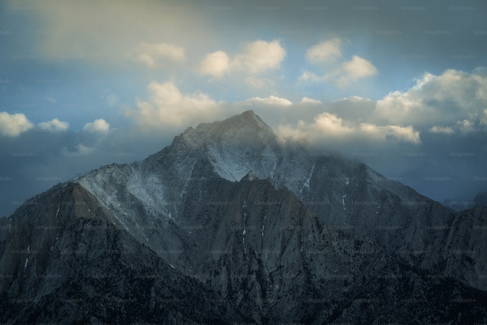 Ein sehr hoher Berg mit Schnee bedeckt unter einem bewölkten Himmel