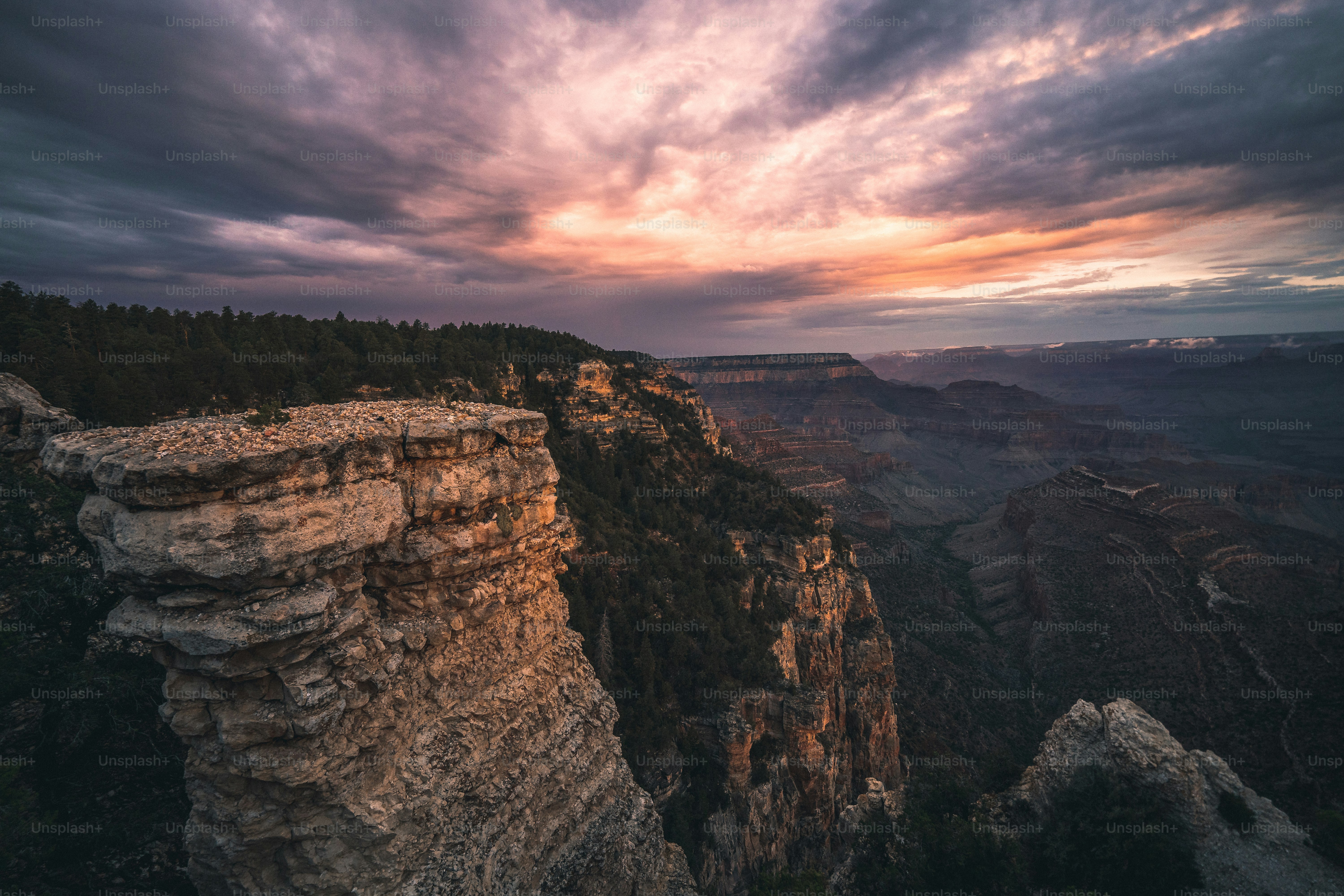 the sun is setting over the mountains and cliffs