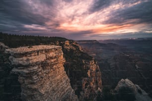 the sun is setting over the mountains and cliffs