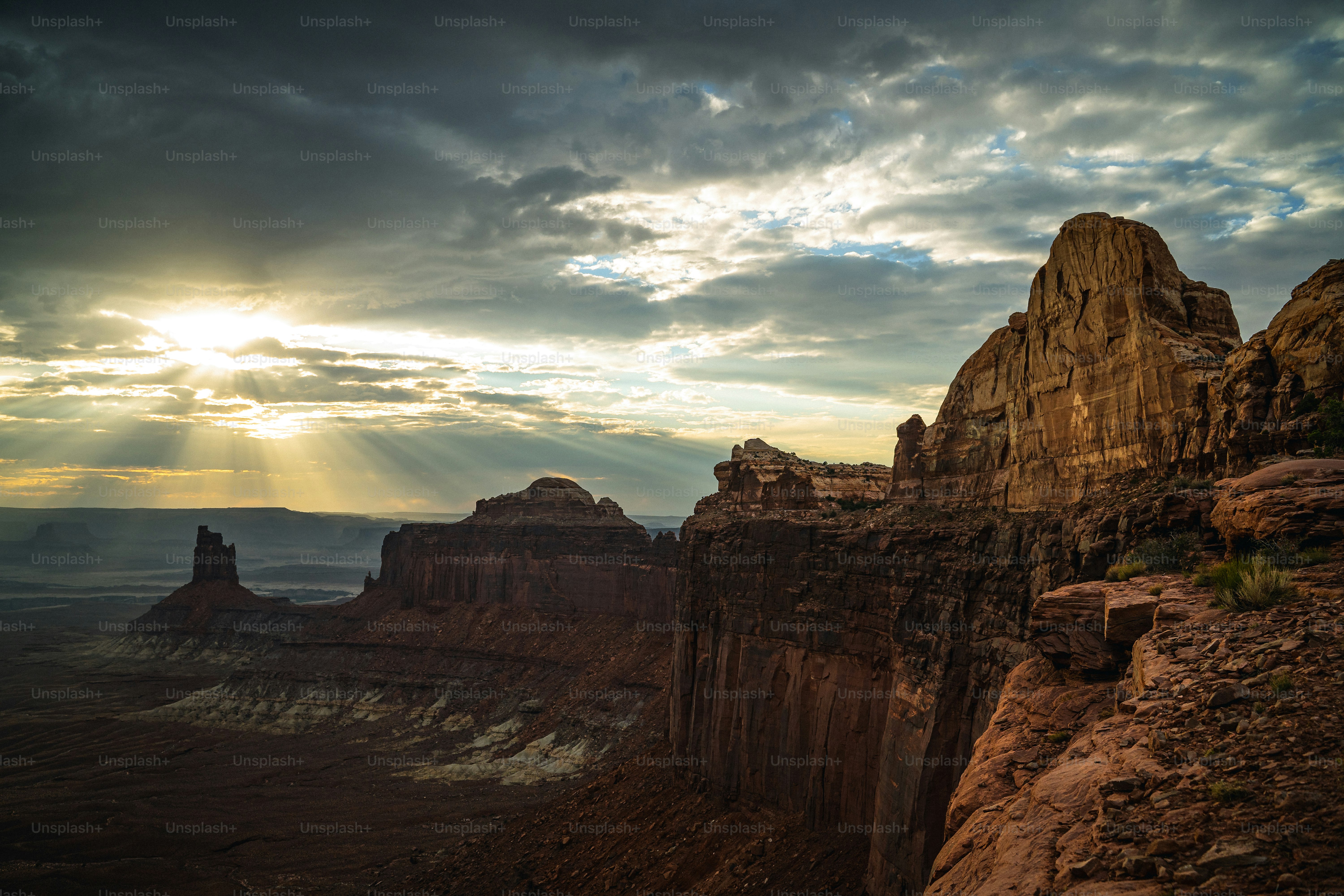 the sun is shining through the clouds over the mountains