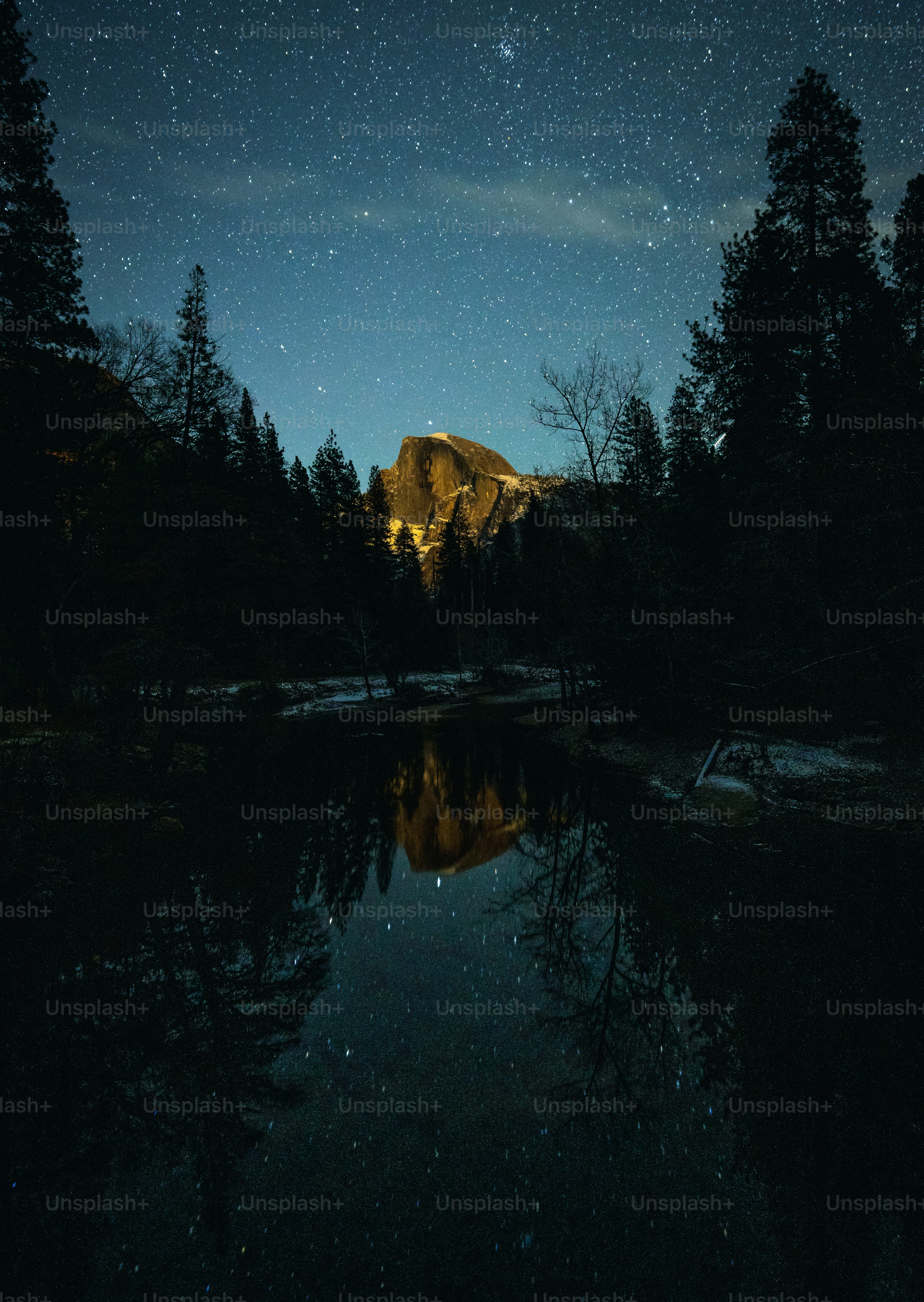 the night sky is reflected in the still water of a mountain lake