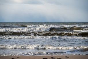 Ein Strand mit Wellen, die ins und aus dem Wasser kommen