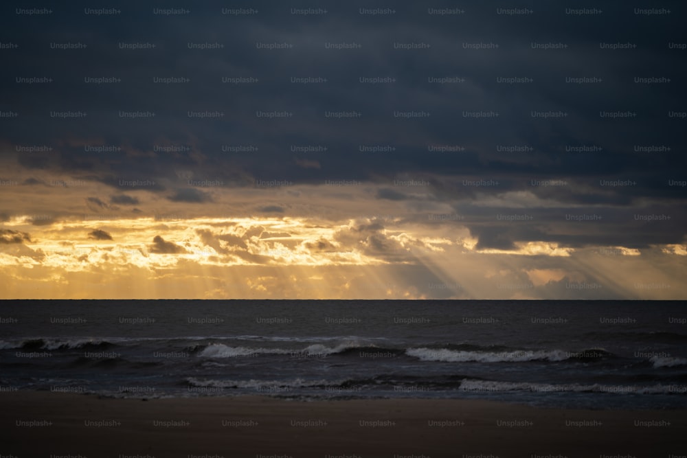 the sun is shining through the clouds over the ocean