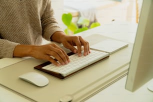 a person typing on a keyboard at a desk