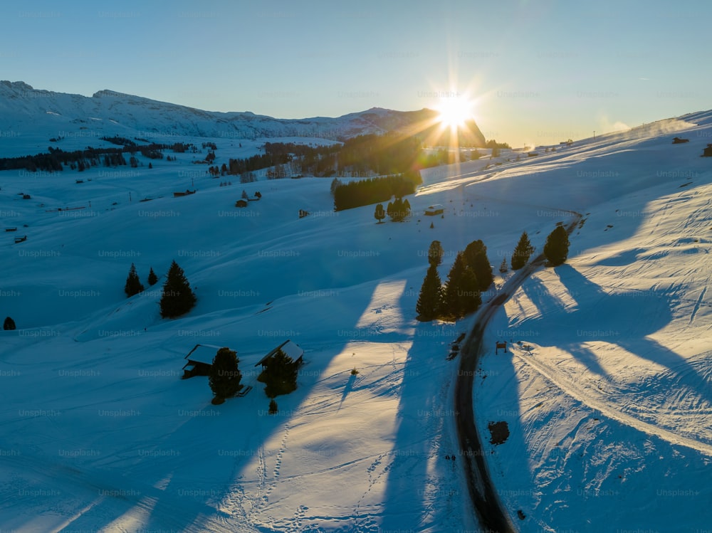 the sun is shining over a snowy mountain