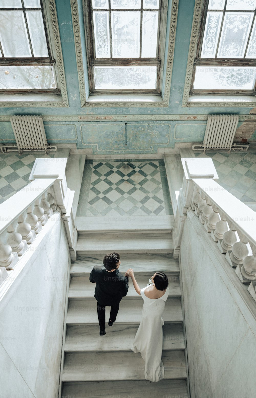 a bride and groom walking down a flight of stairs