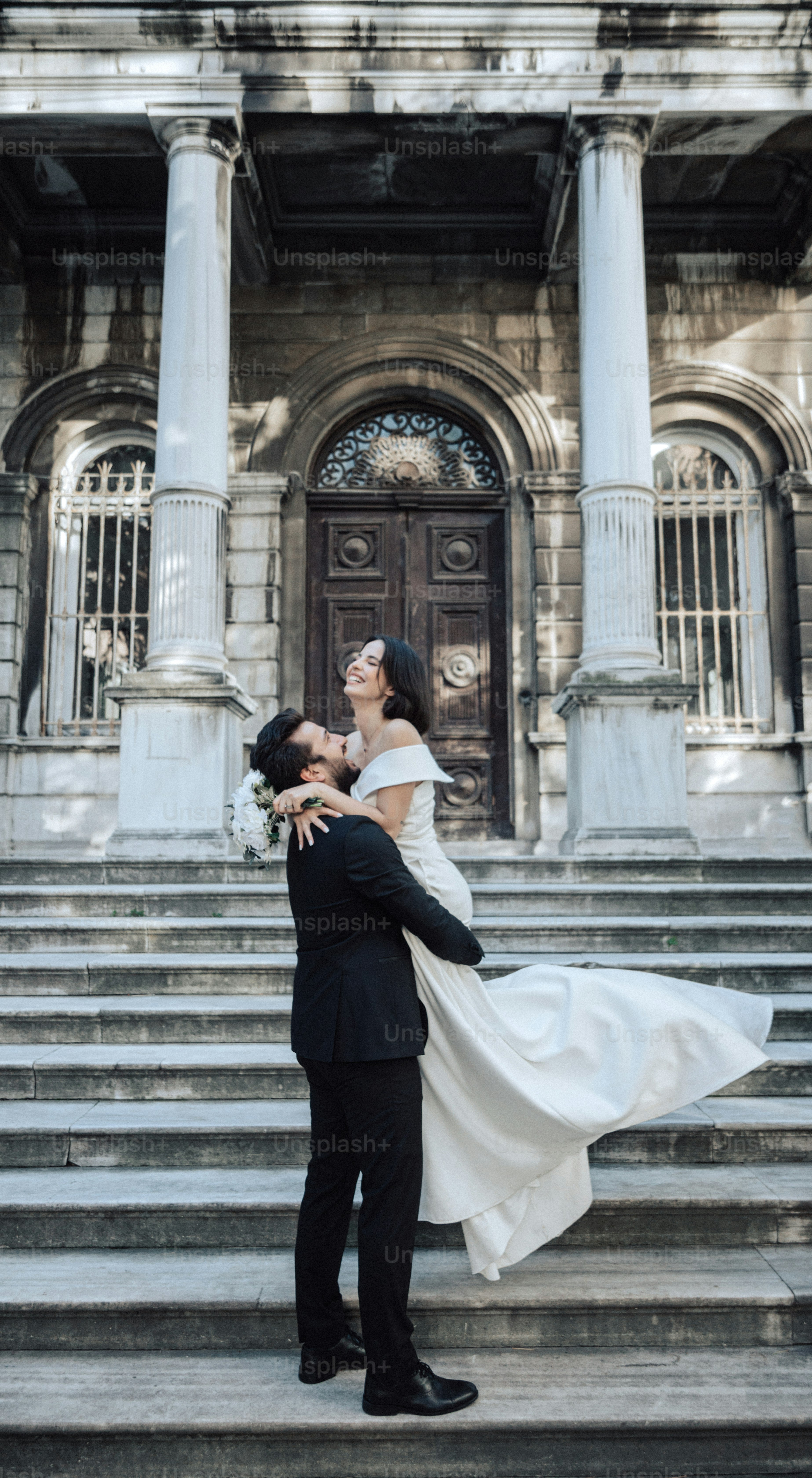a bride and groom standing on the steps of a building