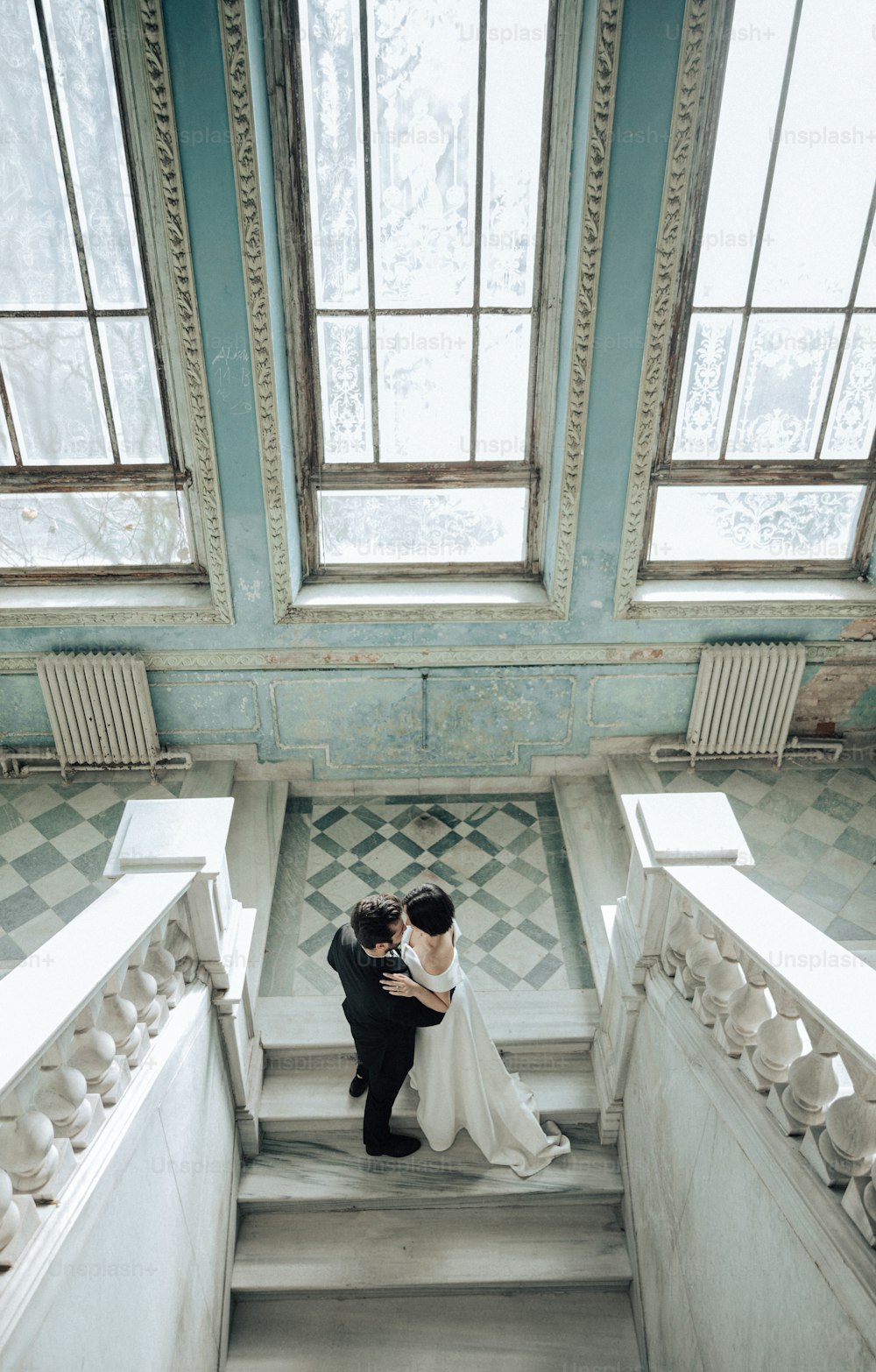 a bride and groom standing on the stairs of a building