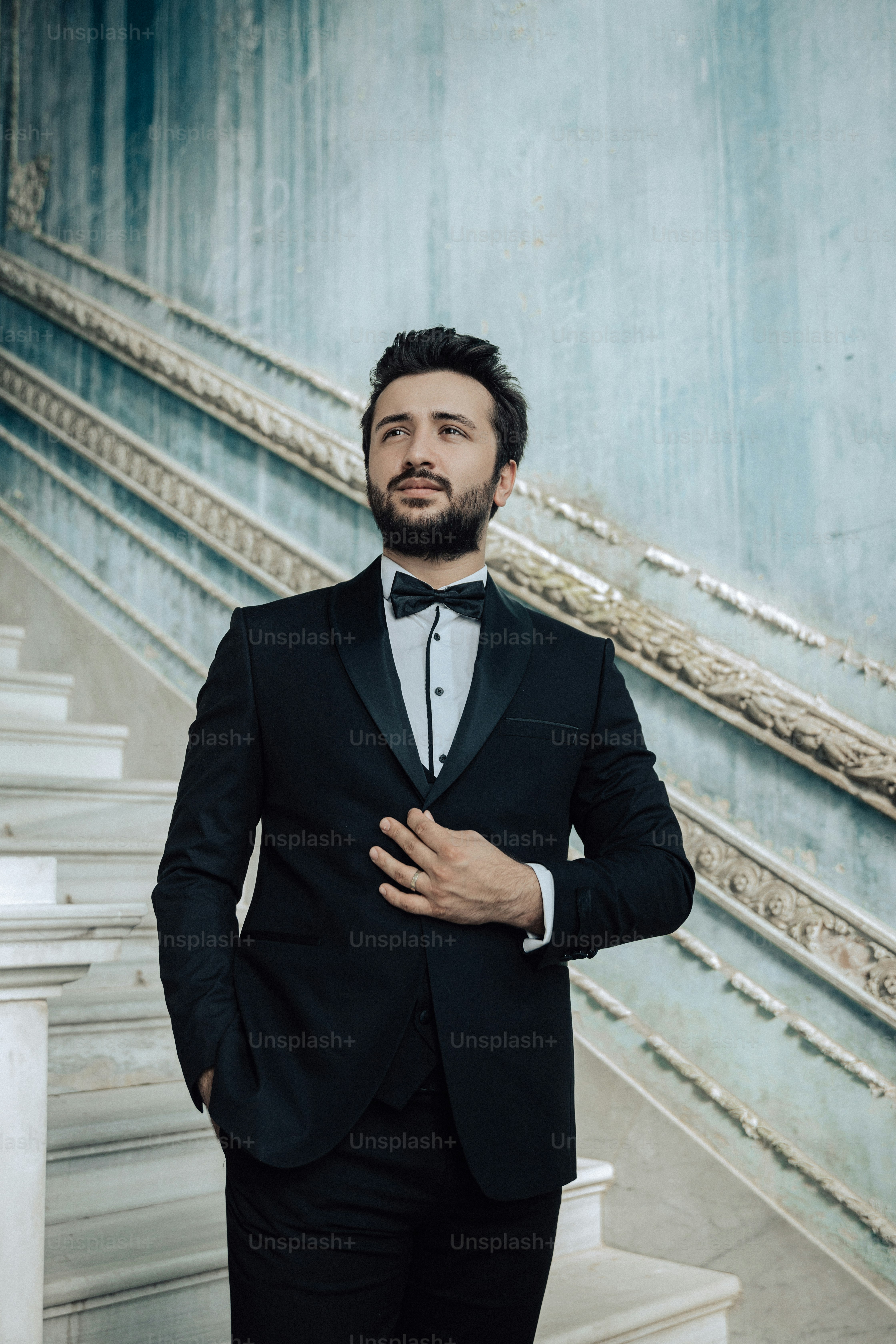 a man in a tuxedo poses for a picture