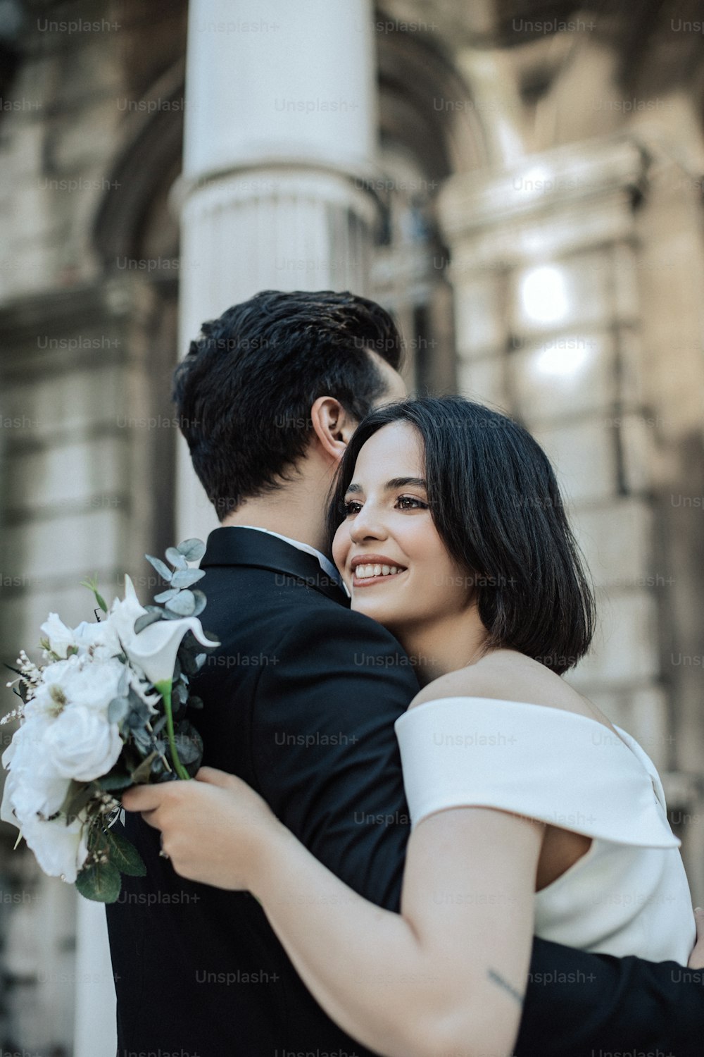 a man and woman hugging each other in front of a building