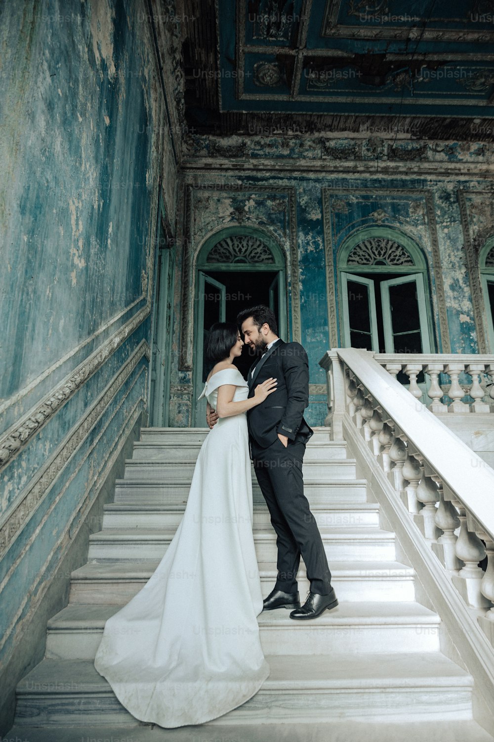 Una novia y un novio besándose en los escalones de un edificio