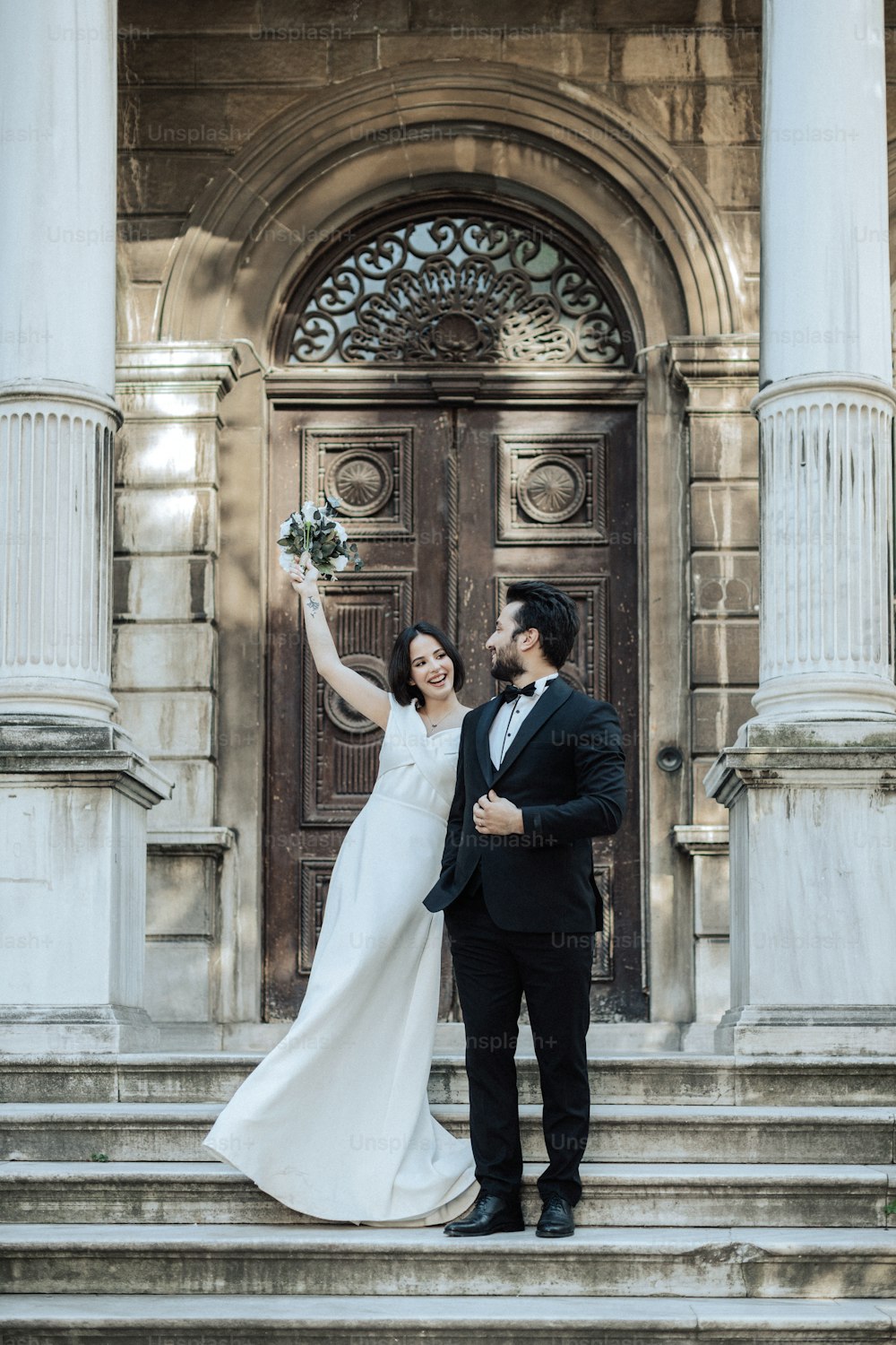 un couple nouvellement marié debout sur les marches d’un immeuble