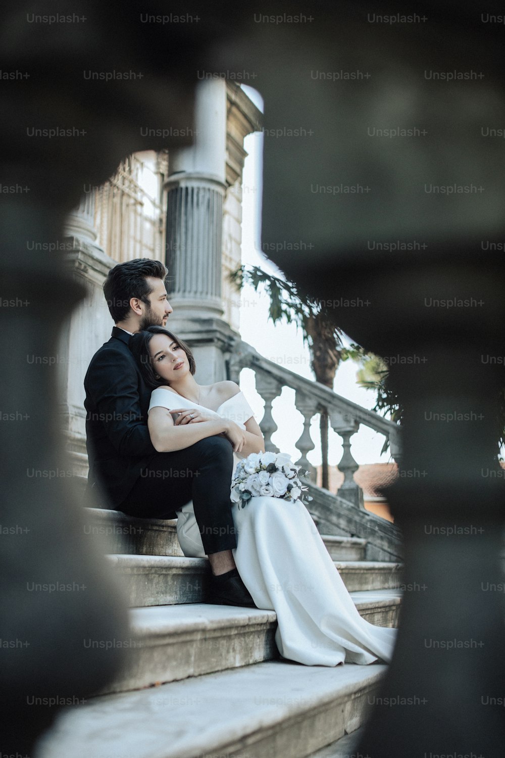 Ein Brautpaar sitzt auf den Stufen eines Gebäudes