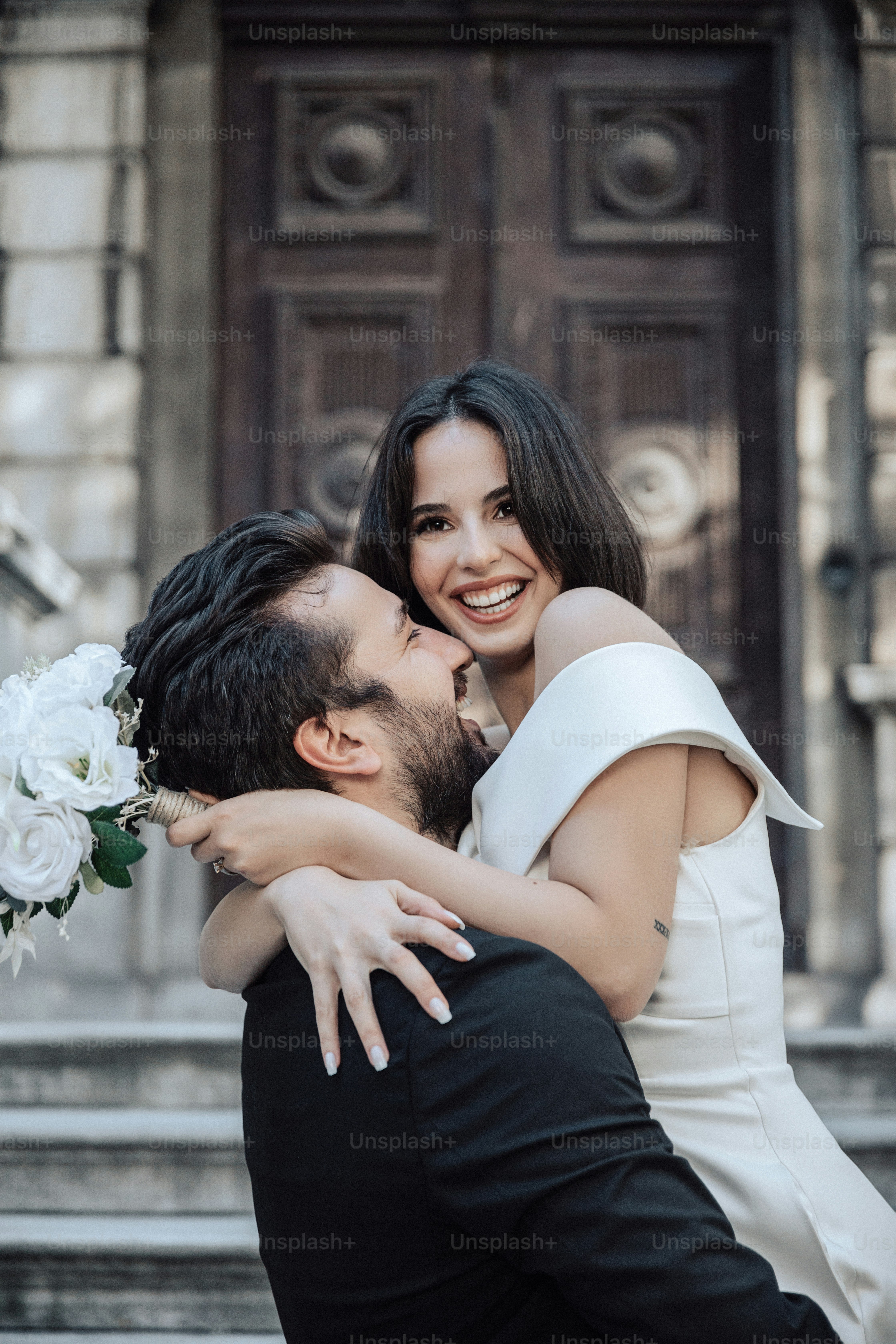 um homem e uma mulher abraçando-se em frente a um edifício