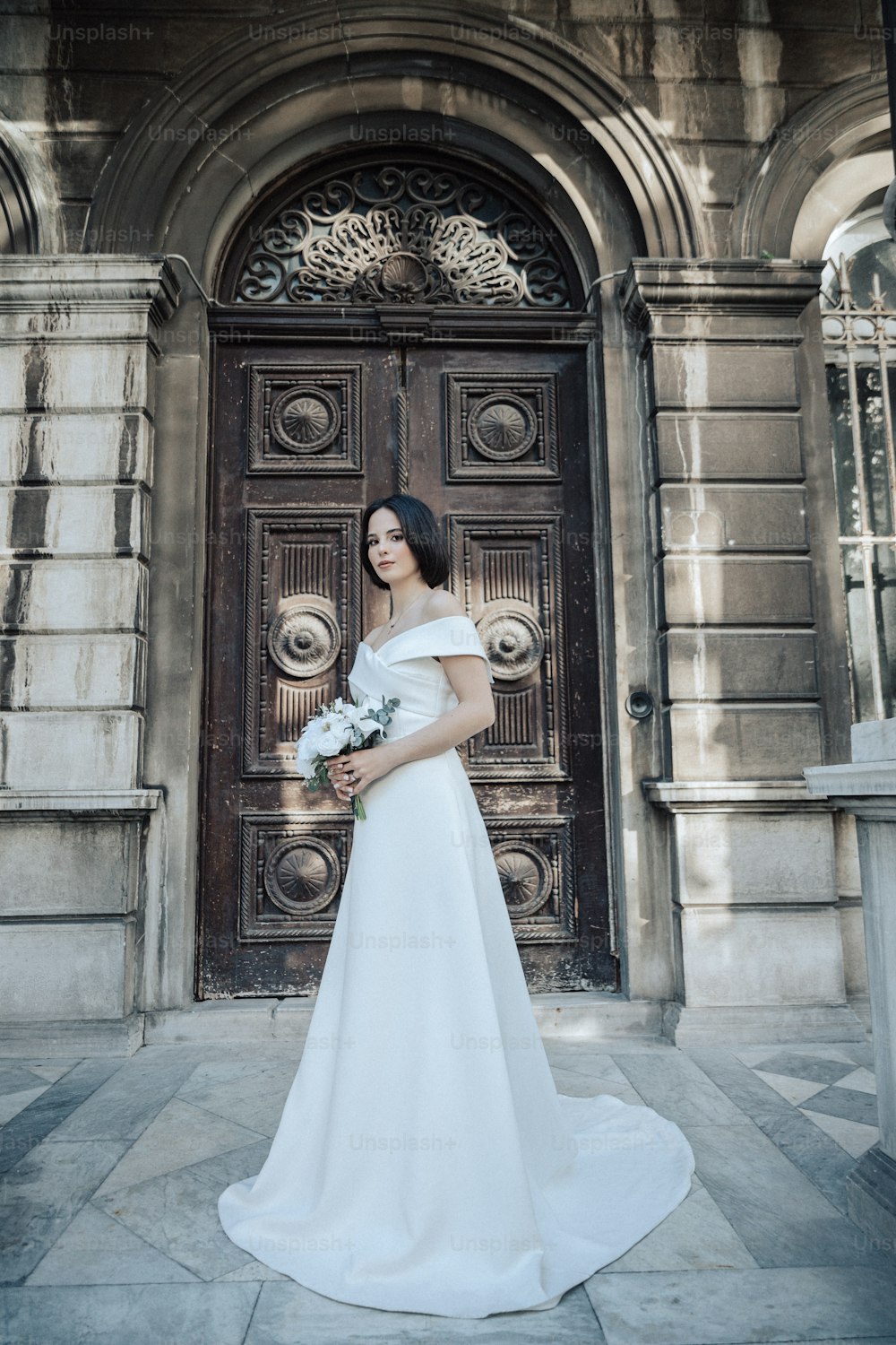a woman in a wedding dress standing in front of a door