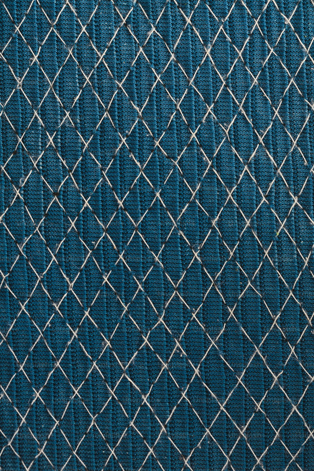 a close up of a blue fabric with a diamond pattern