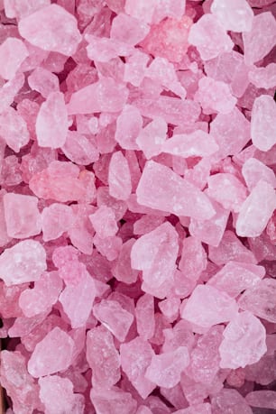 una pila di cristalli di zucchero rosa seduti sopra un tavolo