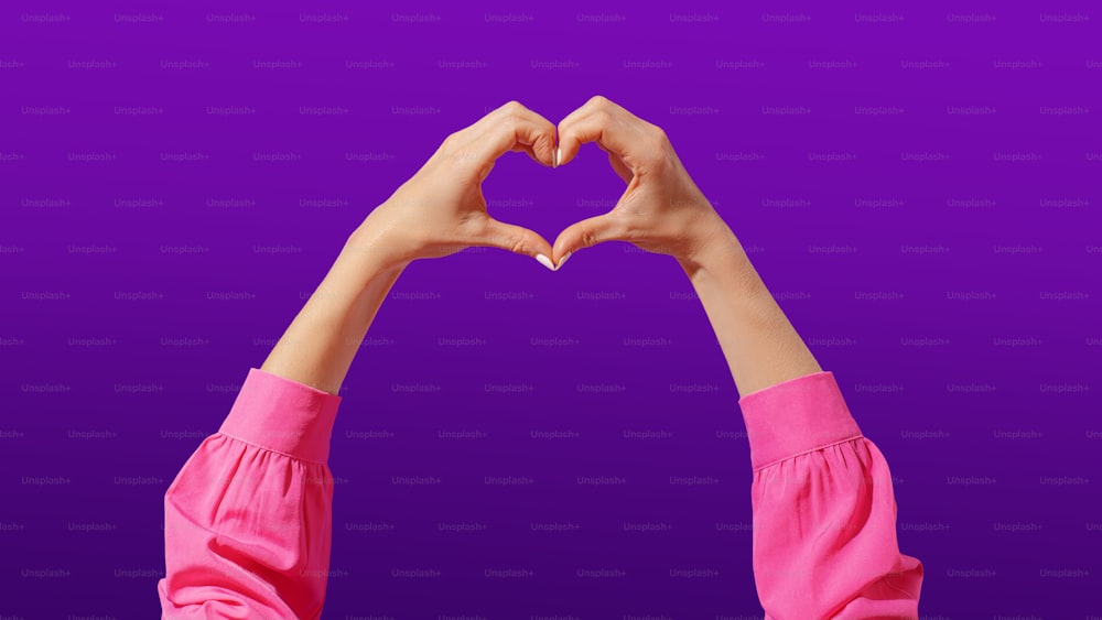 a person making a heart shape with their hands