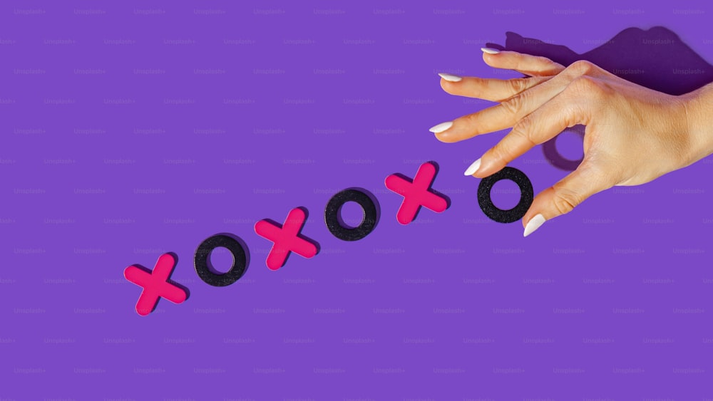 a woman's hand holding a pair of scissors with the word xoxo