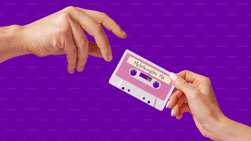 a pair of hands holding a cassette