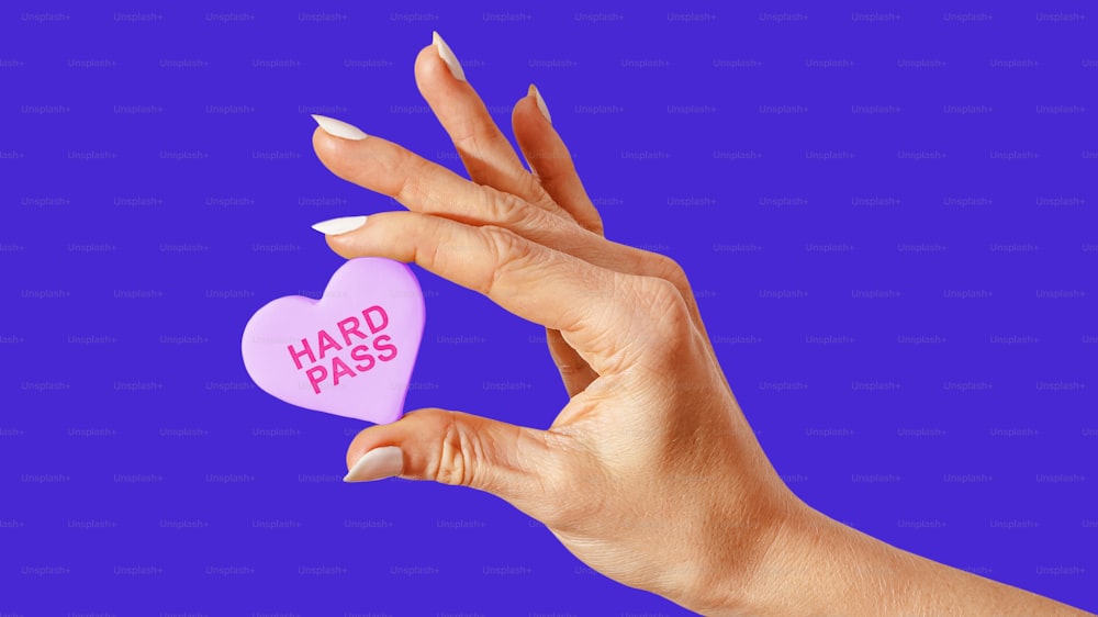 a woman's hand holding a heart shaped candy