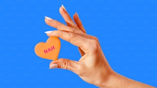 a woman's hand holding an orange heart with the word han on it