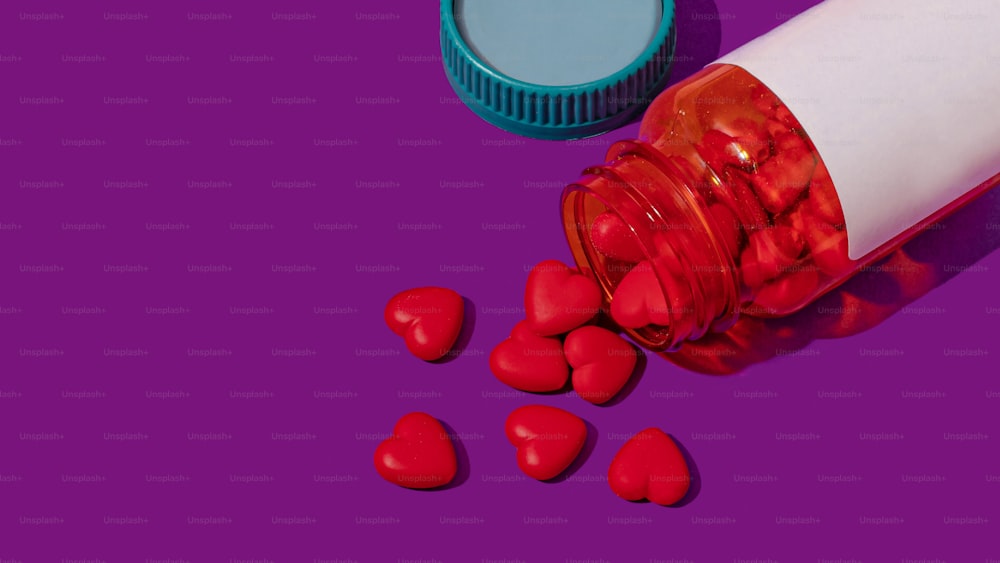 a pill bottle with red hearts spilling out of it