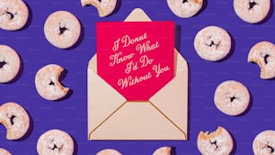 a pink envelope with a pink heart on it surrounded by donuts