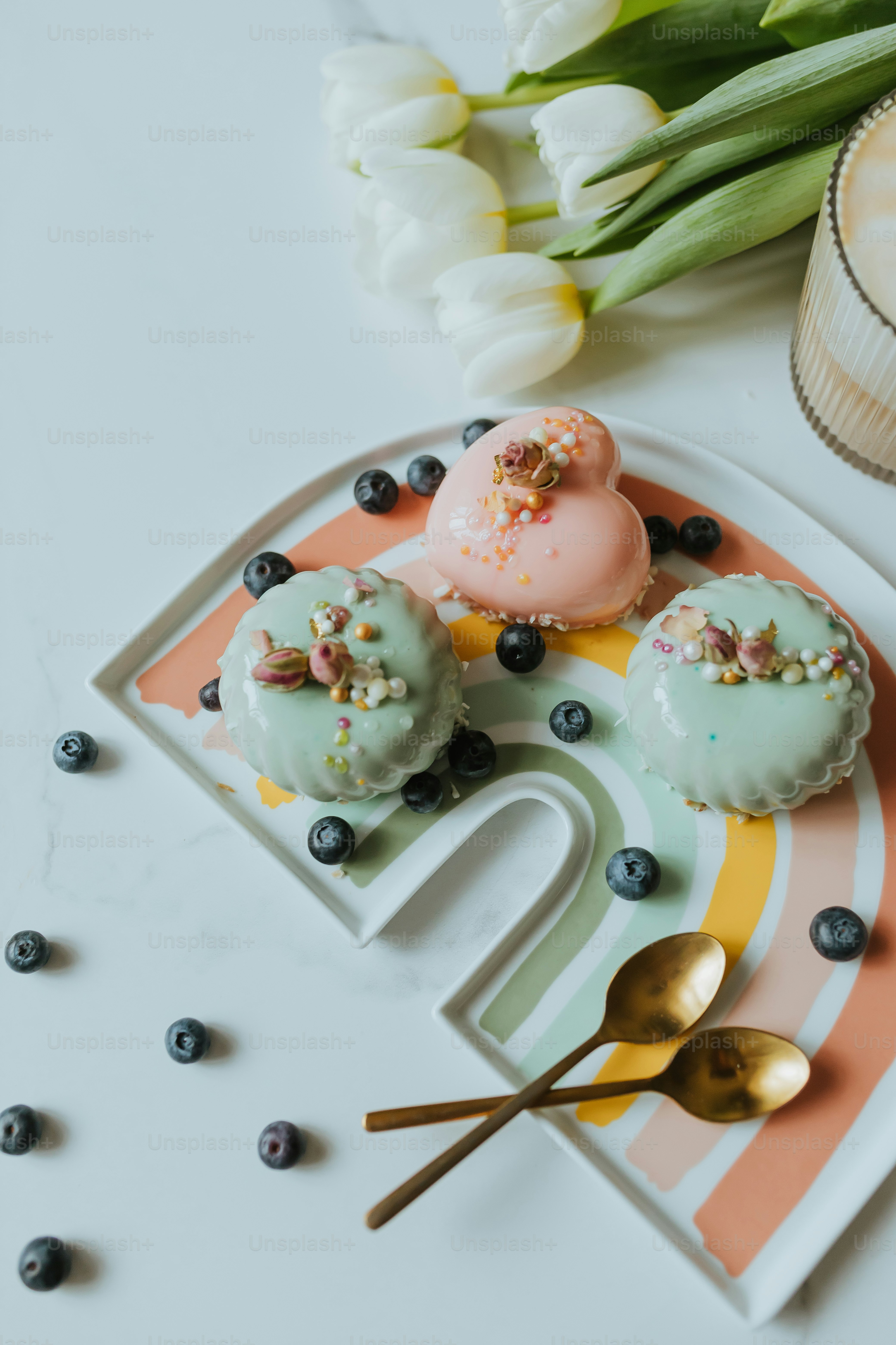 a plate topped with donuts next to a vase of flowers