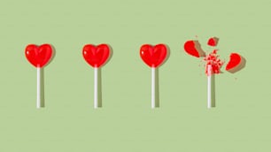 a row of red lollipops on a green background