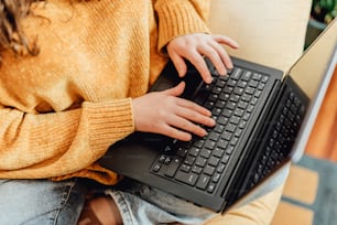 a woman sitting on a couch using a laptop computer