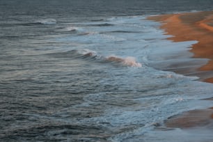 a sandy beach with waves coming in to shore