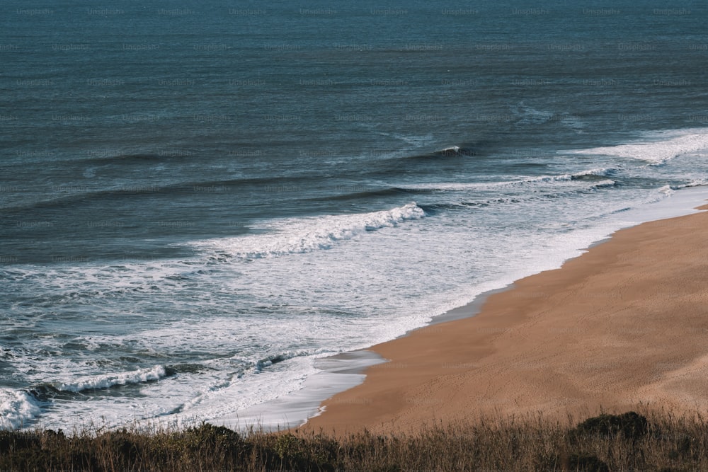 a view of a beach with waves coming in from the ocean