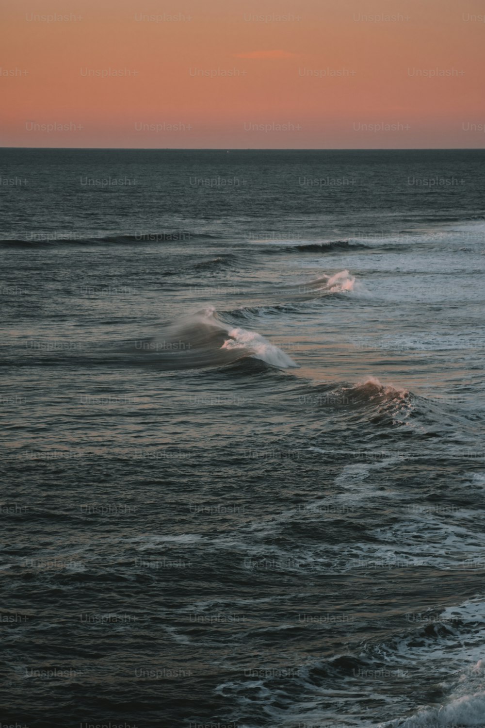 the sun is setting over the ocean waves