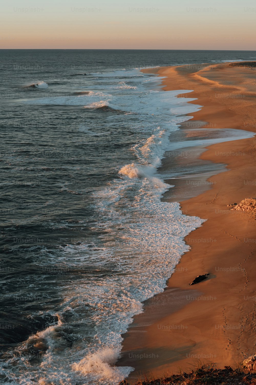 Blick auf einen Strand mit Wellen, die vom Meer kommen