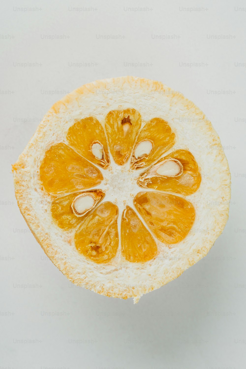 an orange cut in half on a white surface