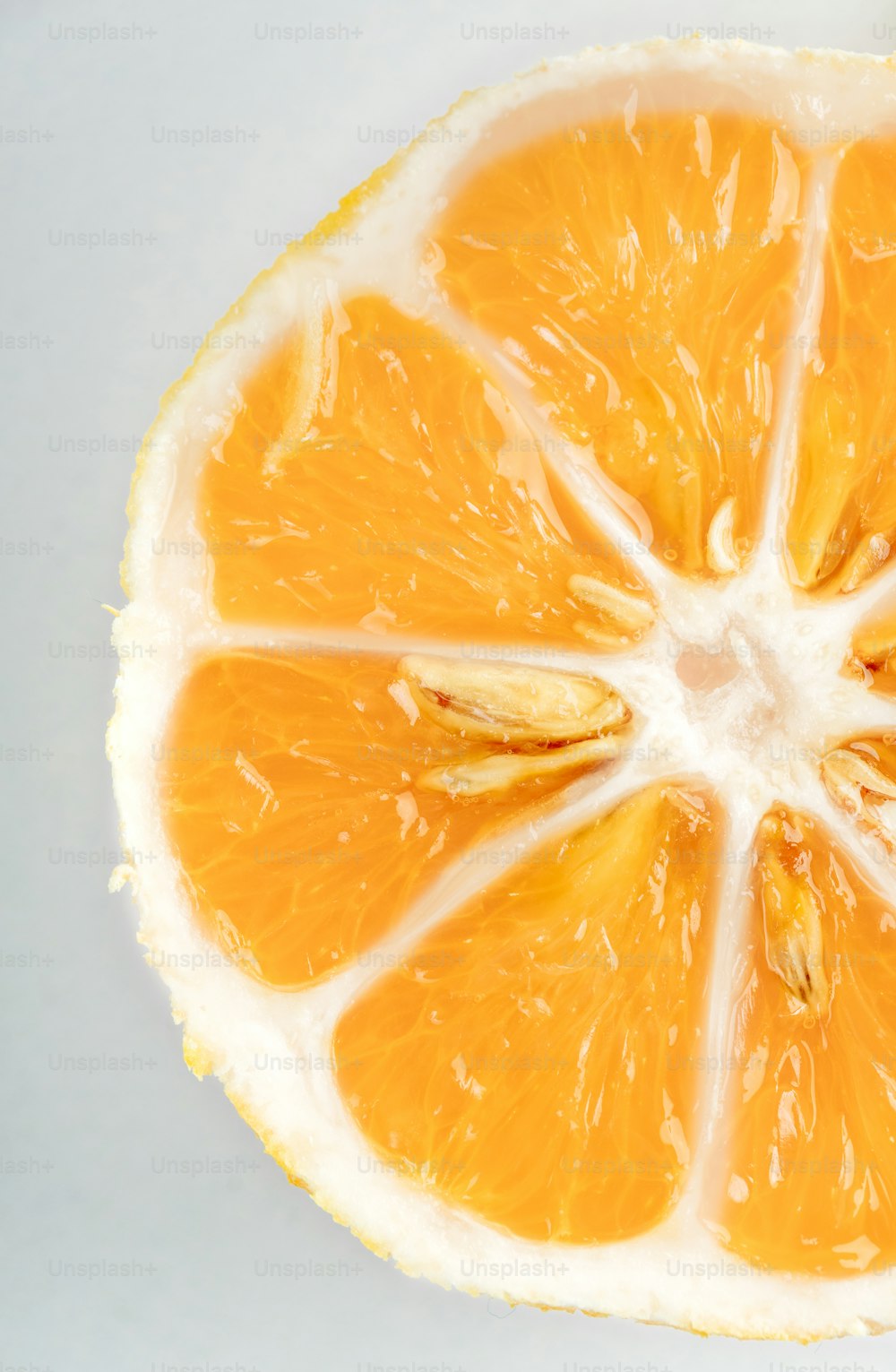 una naranja cortada por la mitad sobre una superficie blanca