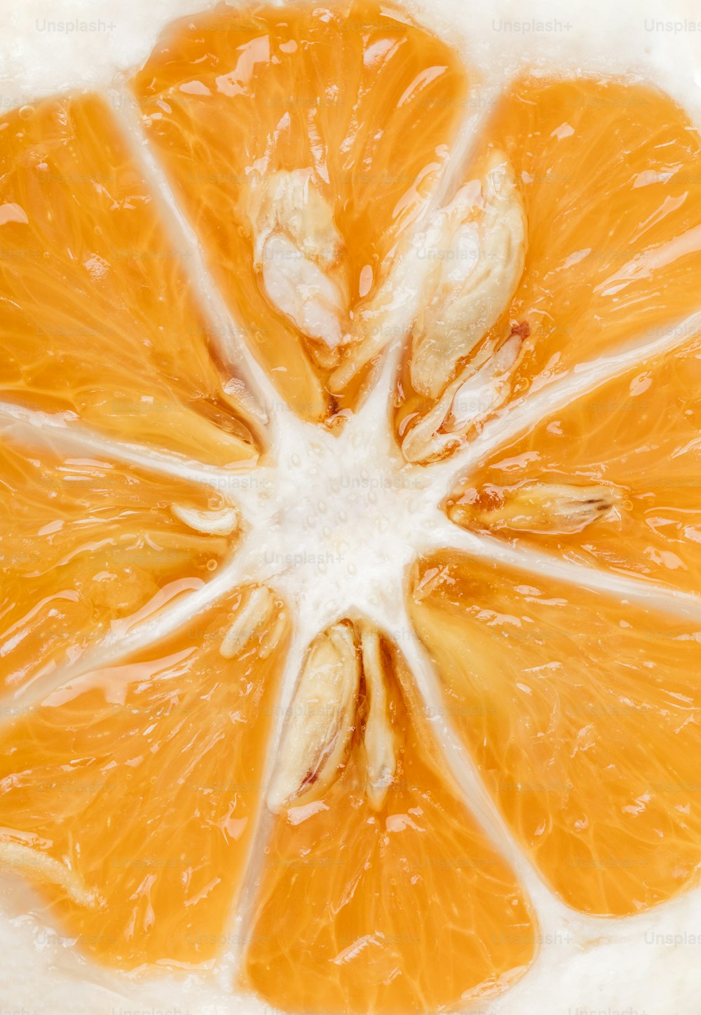 una naranja cortada por la mitad sobre una superficie blanca