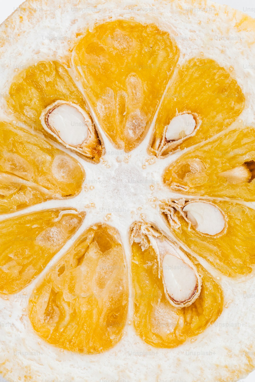 a close up of a sliced orange on a white surface