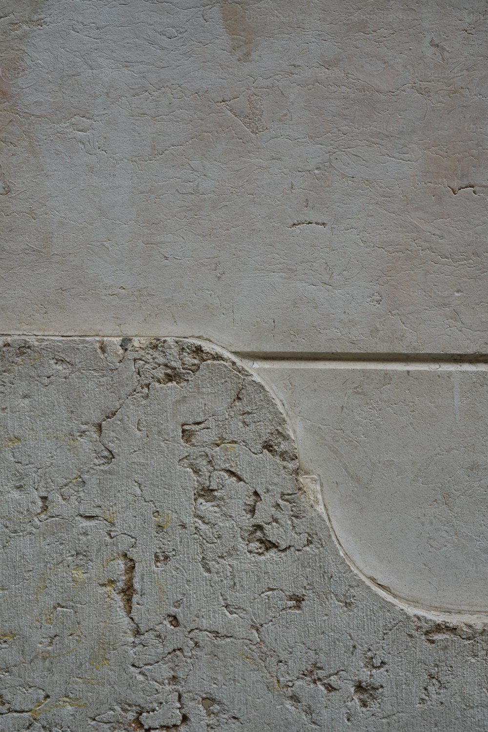 a bird is perched on the corner of a concrete wall