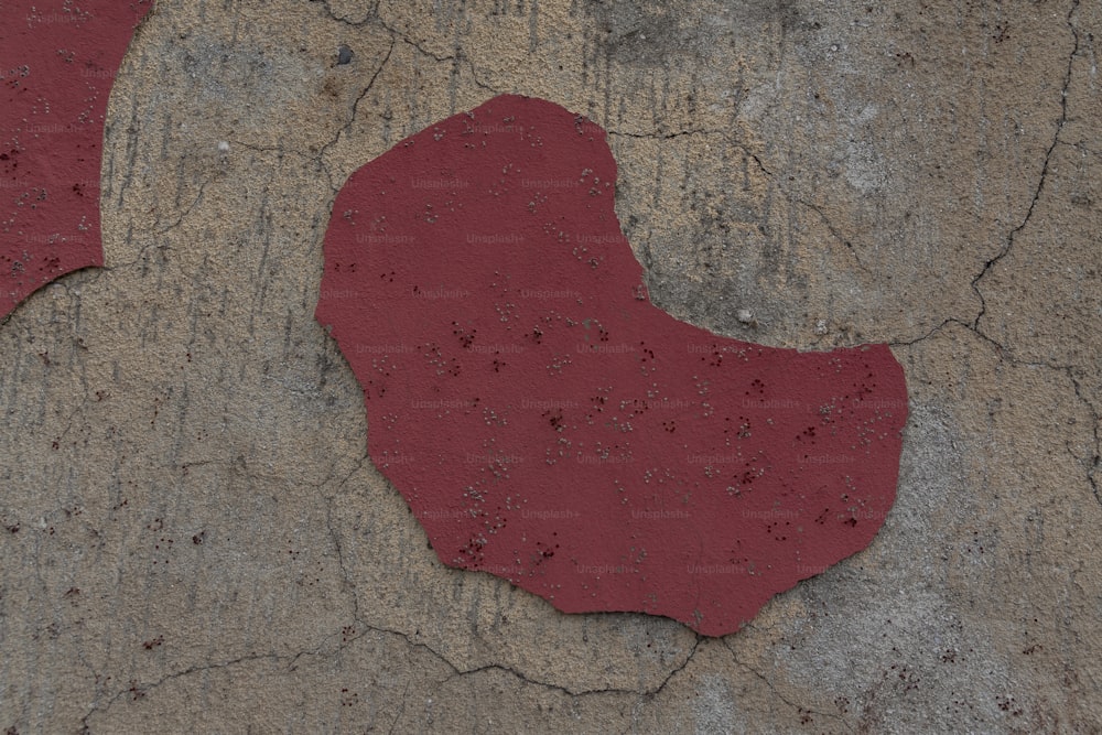 a red piece of paper sitting on top of a cement slab