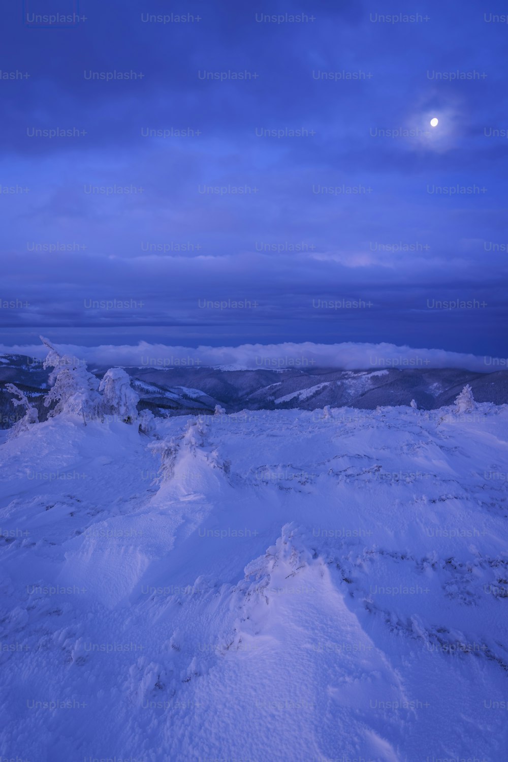 a snow covered mountain under a cloudy blue sky